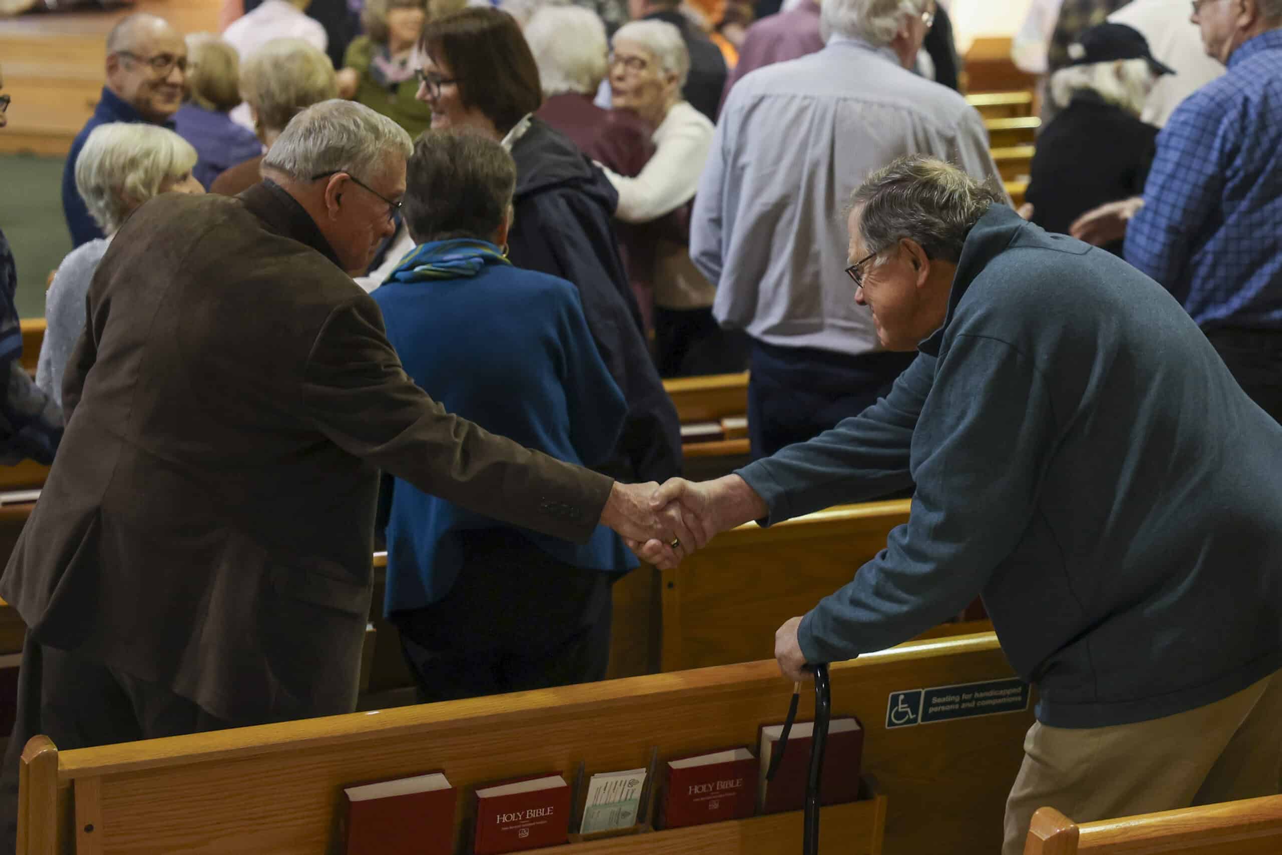 Incarnation Lutheran Church congregation warmly greeting each other during a service or community event, showcasing fellowship and faith in a welcoming religious environment.