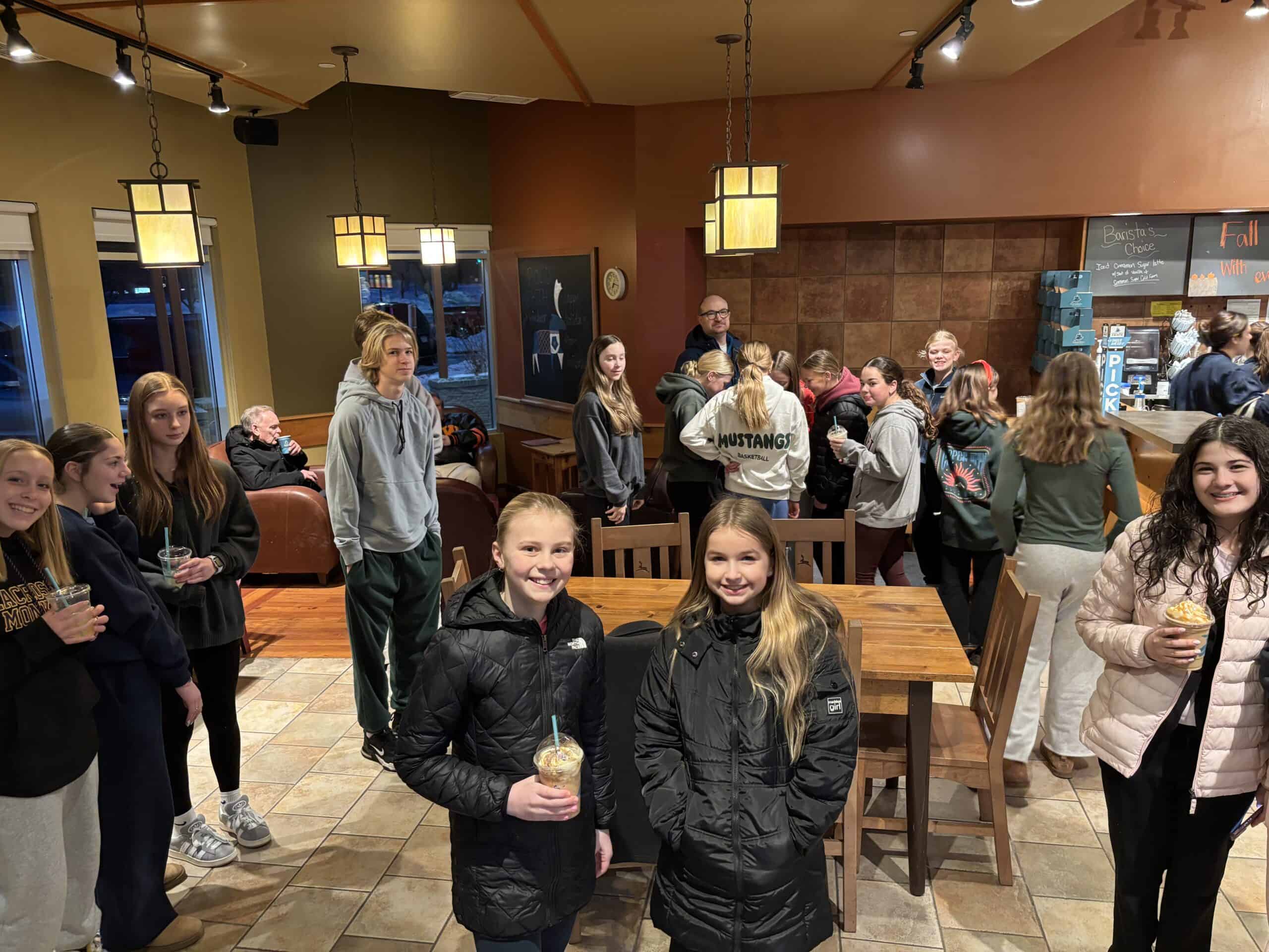 Incarnation Lutheran Church community gathering with young people socializing indoors, enjoying drinks, and engaging in activities at a warm, welcoming church event space.