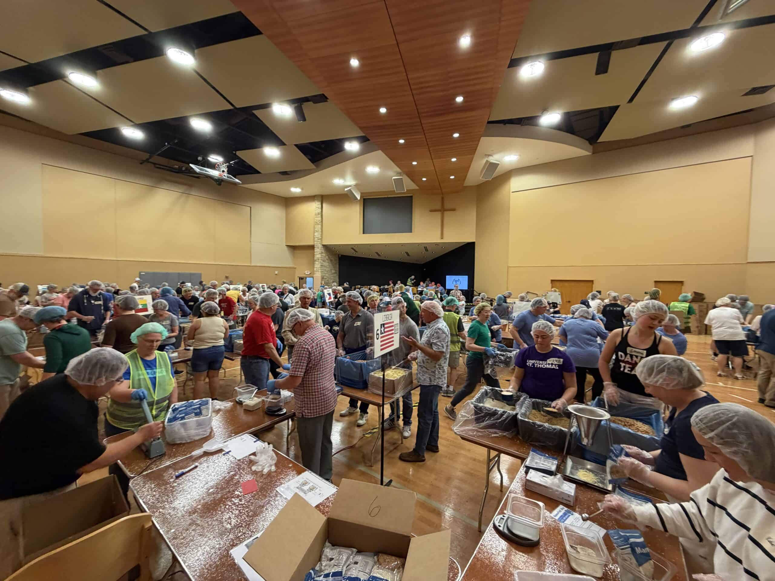 Incarnation Lutheran Church community event with volunteers packing food in a spacious hall.