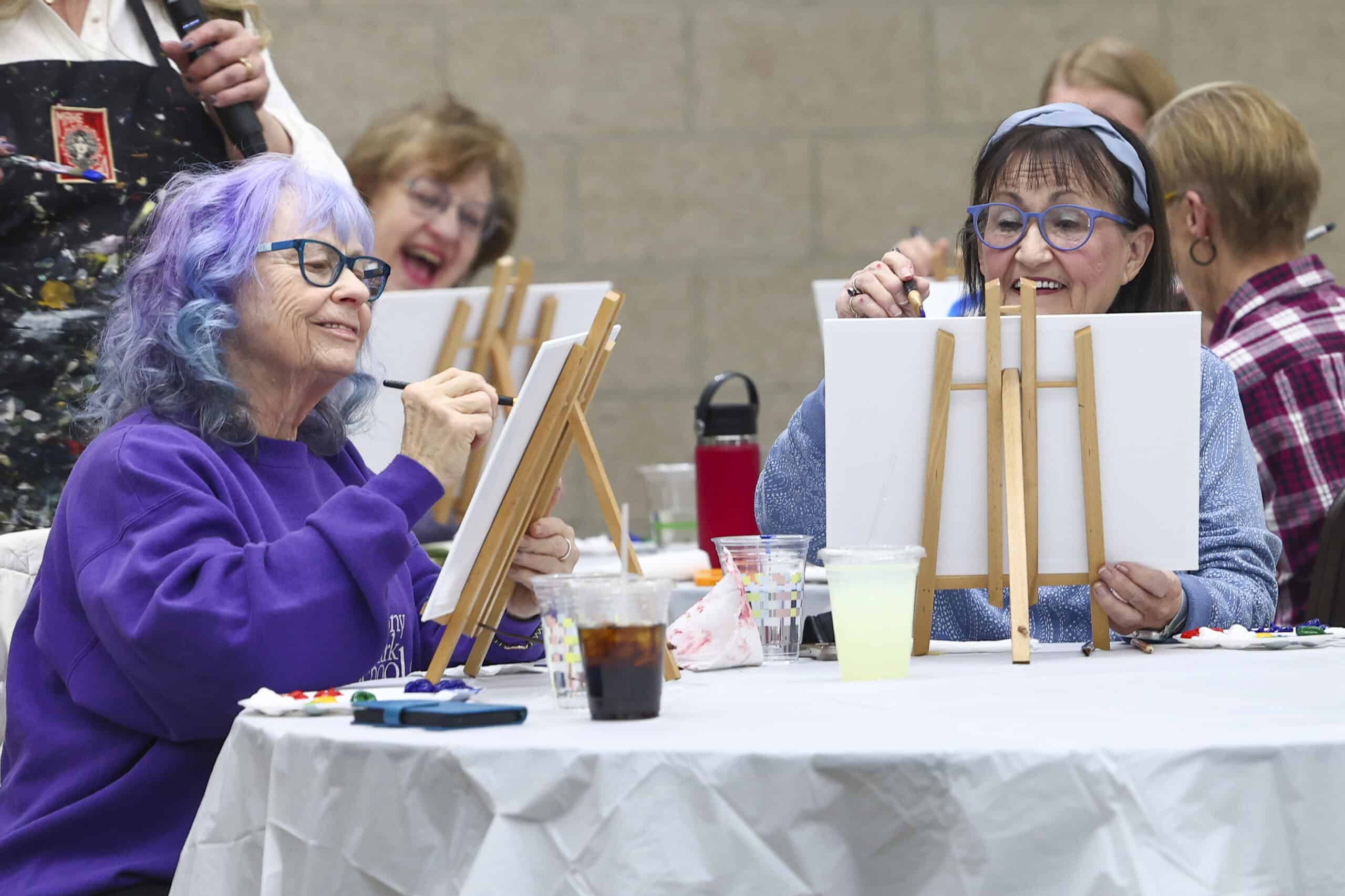 Group of women painting on canvases at Incarnation Lutheran Church community event.