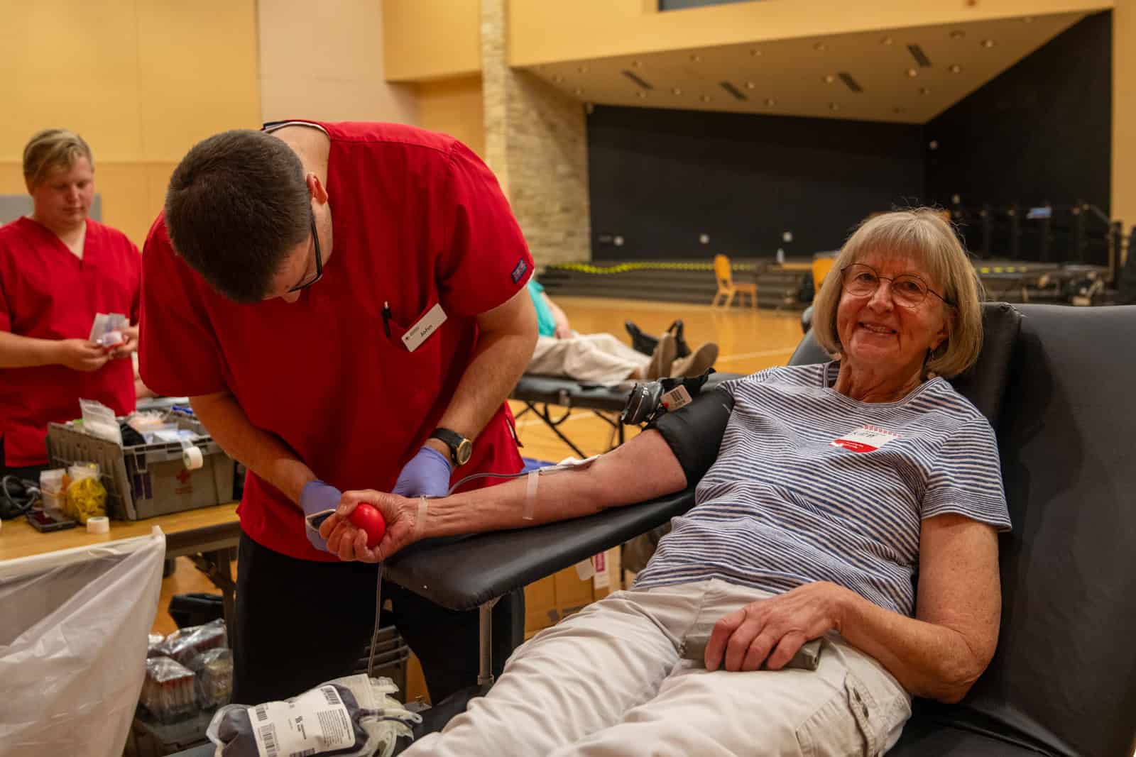 Blood Drive A woman donating blood at Incarnation Lutheran Church blood drive, smiling and seated comfortably while a healthcare worker assists her.