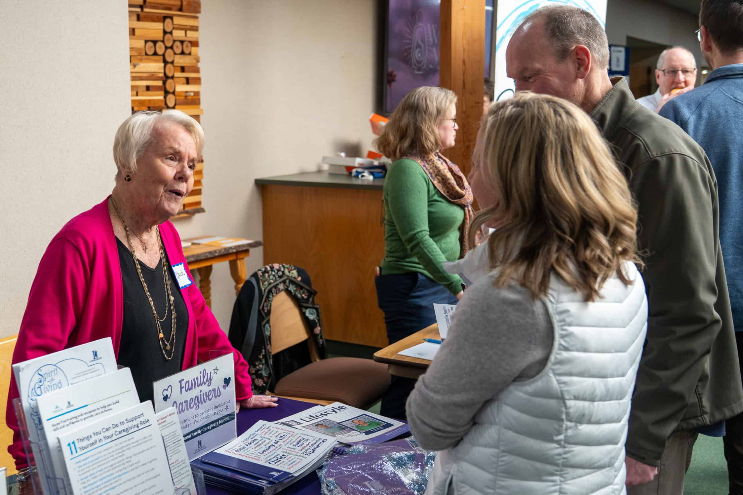 People engaging at Incarnation Lutheran Church during a community event, with informational displays and a focus on caring for older adults.