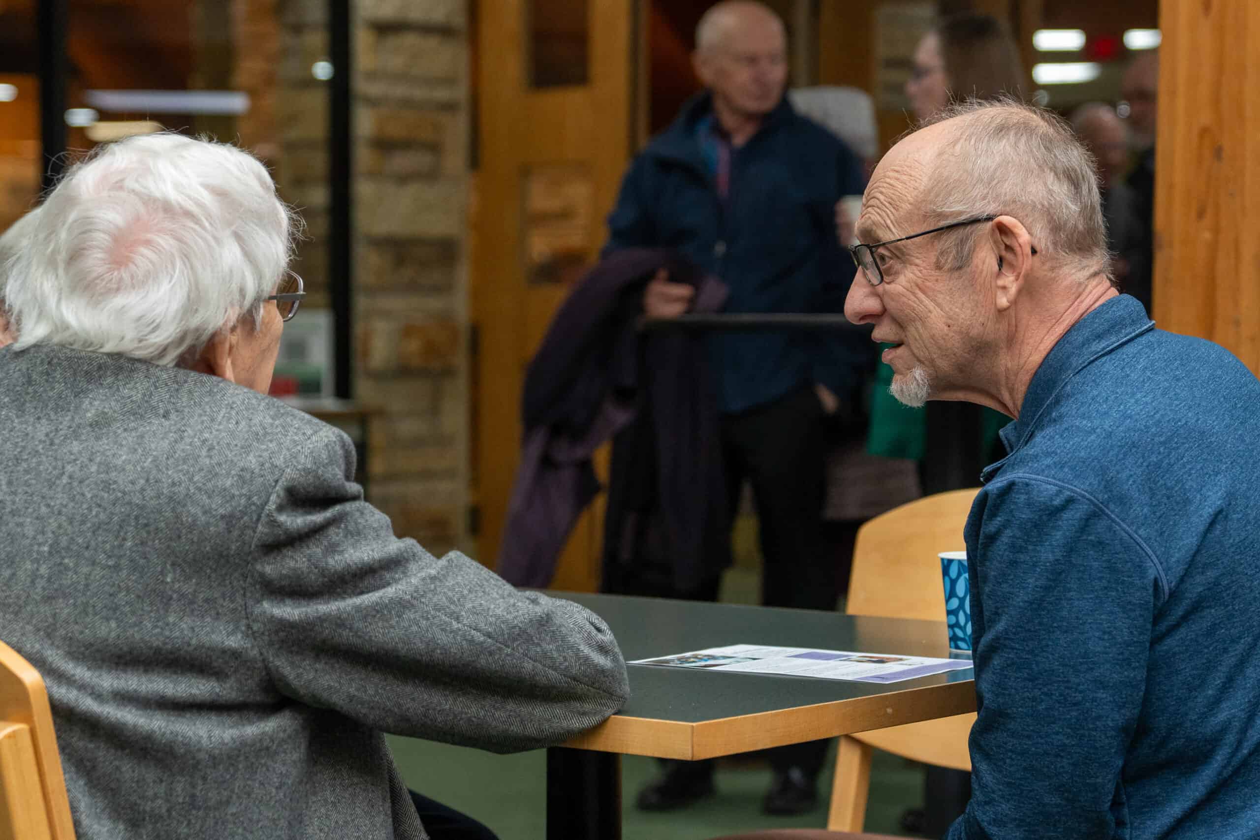 A priest at Incarnation Lutheran Church shaking hands with a young person during a community event, highlighting faith and inclusion.